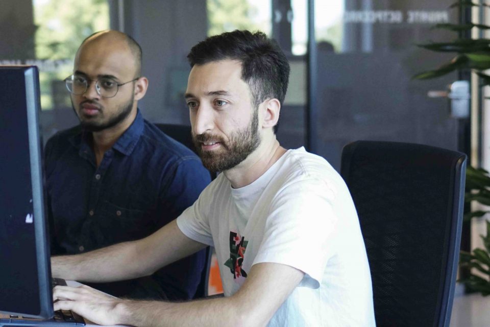 two young men looking into a computer screen