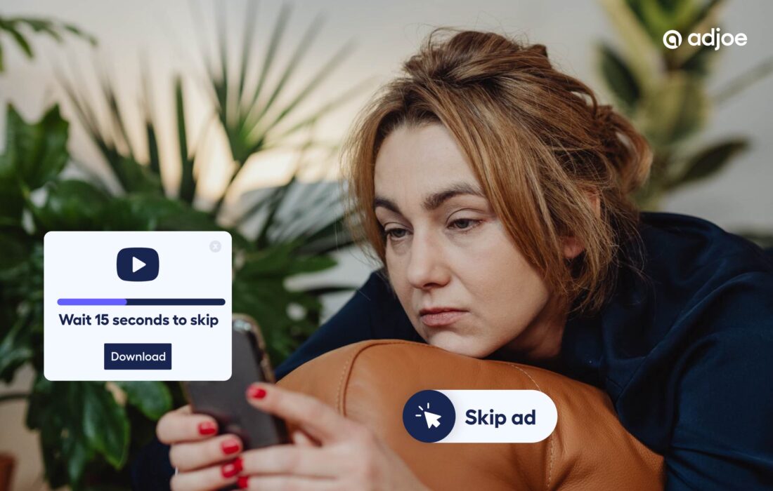 young woman with reddish hair lying down inside looking fed up with her phone