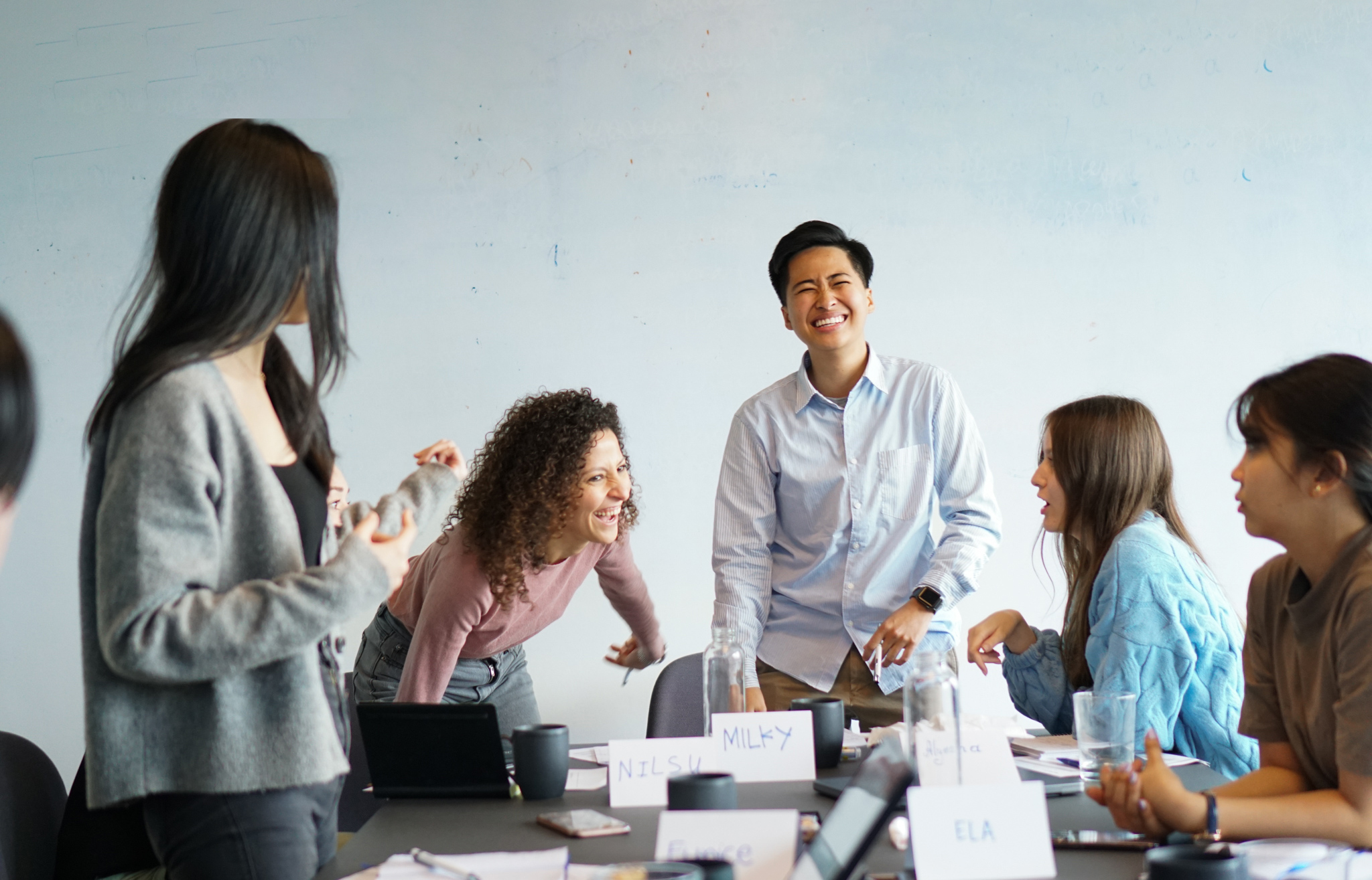 a group of young people laughing in a meeting room