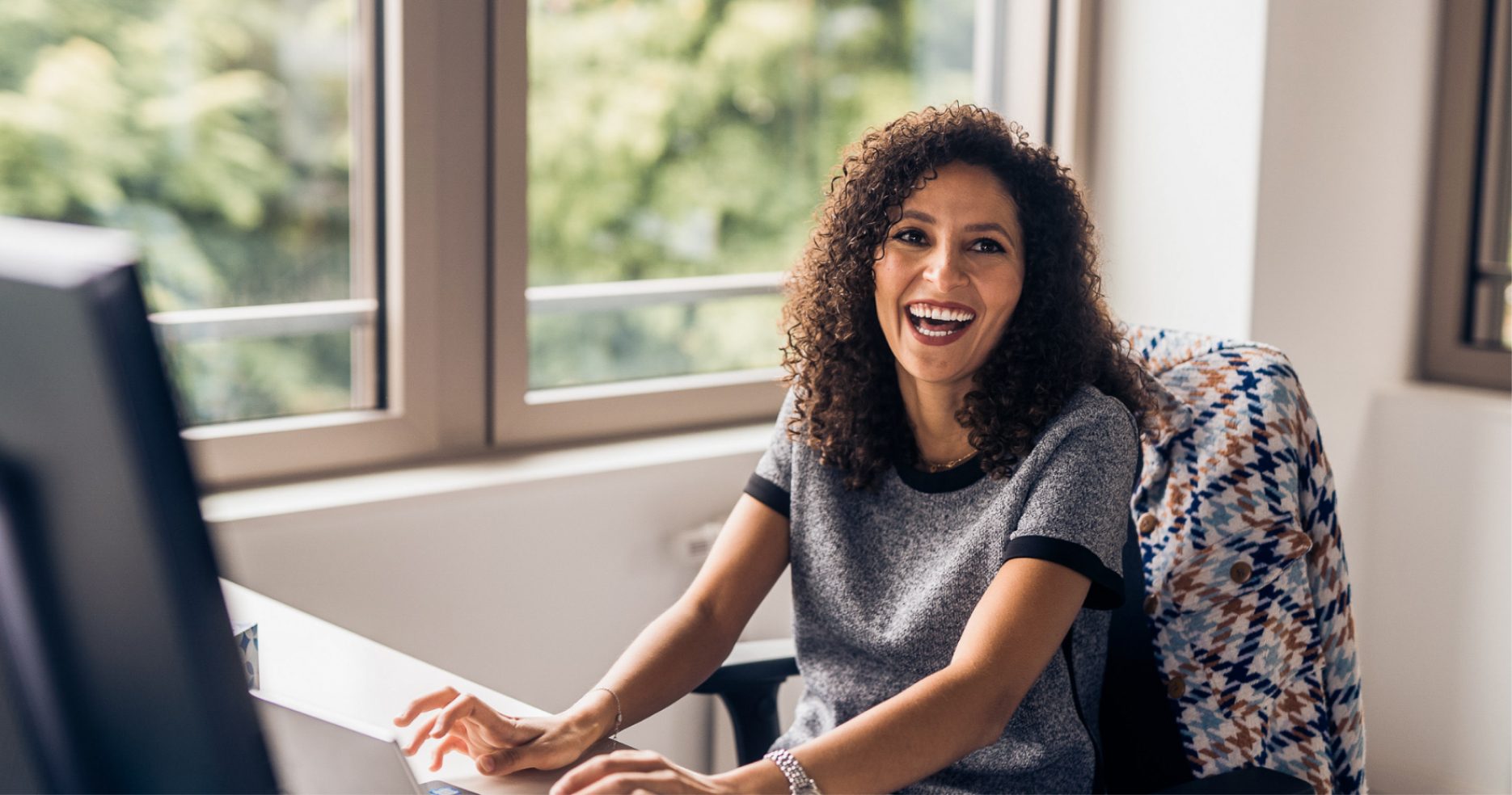 young woman laughing inside the office of an international tech company