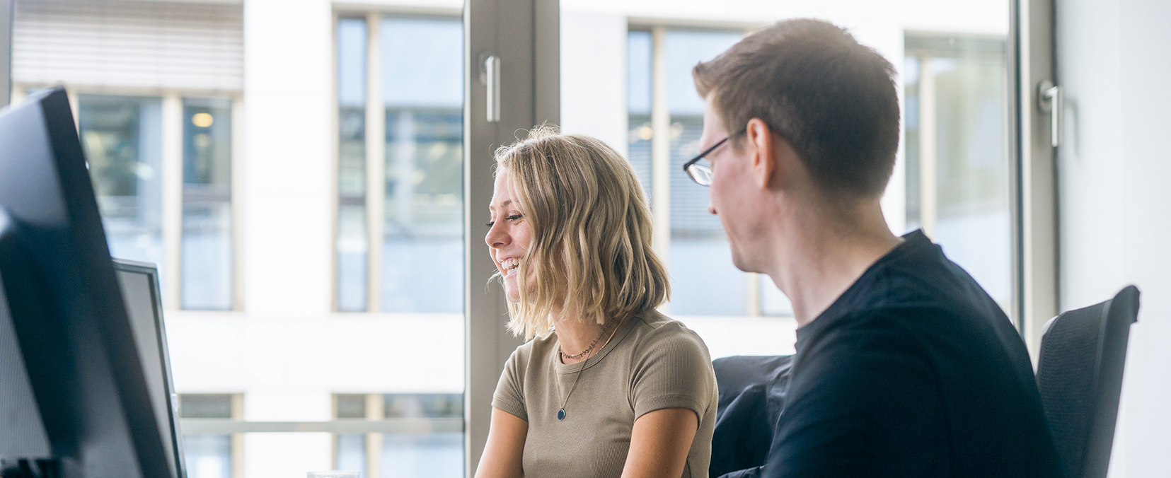 two young employees looking at a monitor in the office