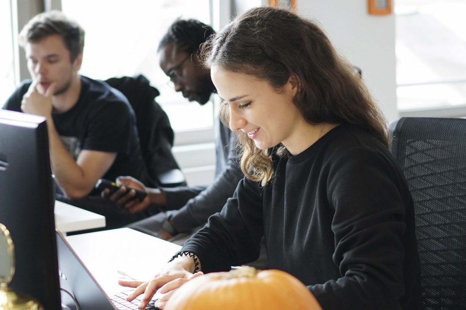 young woman in tech team in office looking down at keyboard