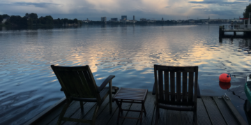 two chairs on a deck looking out onto a lake