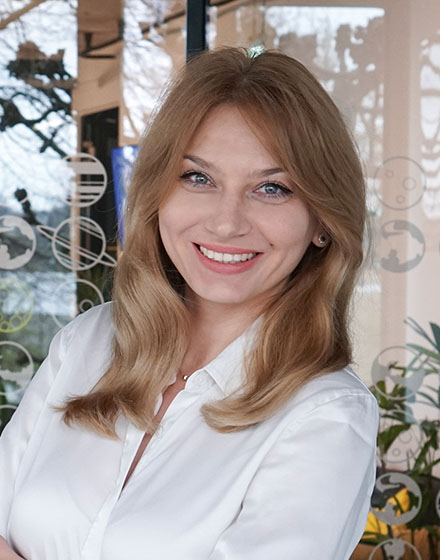 young woman in white shirt smiling at camera