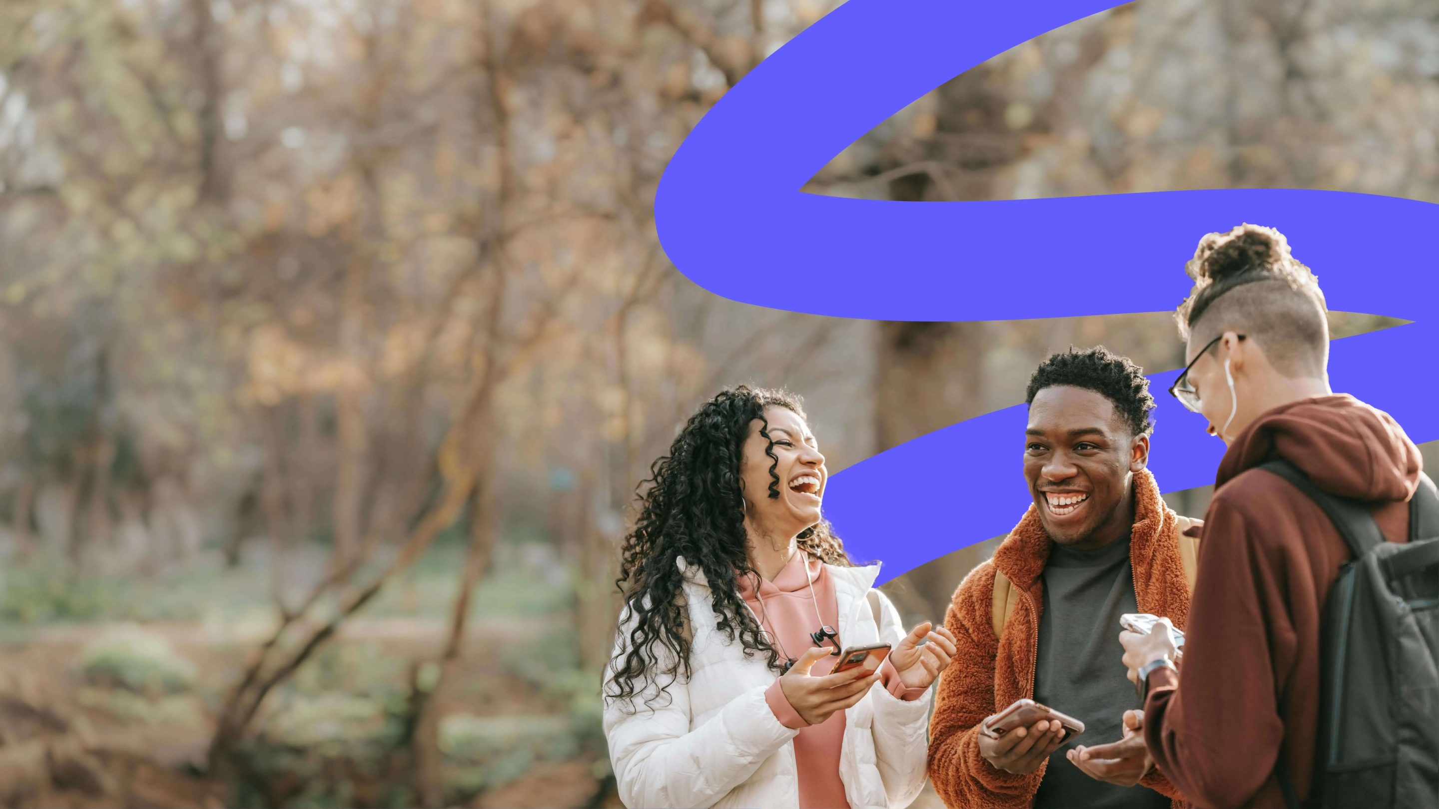 three young people outdoors looking at their phones