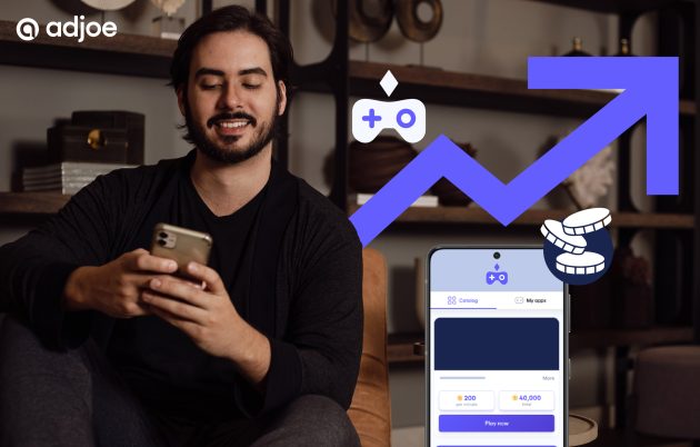 young man with beard smiling into camera with incons showing playtime and coins and a phone screen