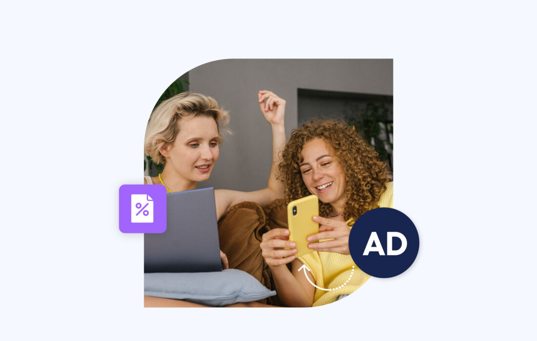 two young women indoors smiling at a phone screen